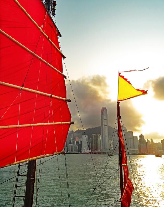 Segel einer Dschunke vor der Skyline von Hongkong